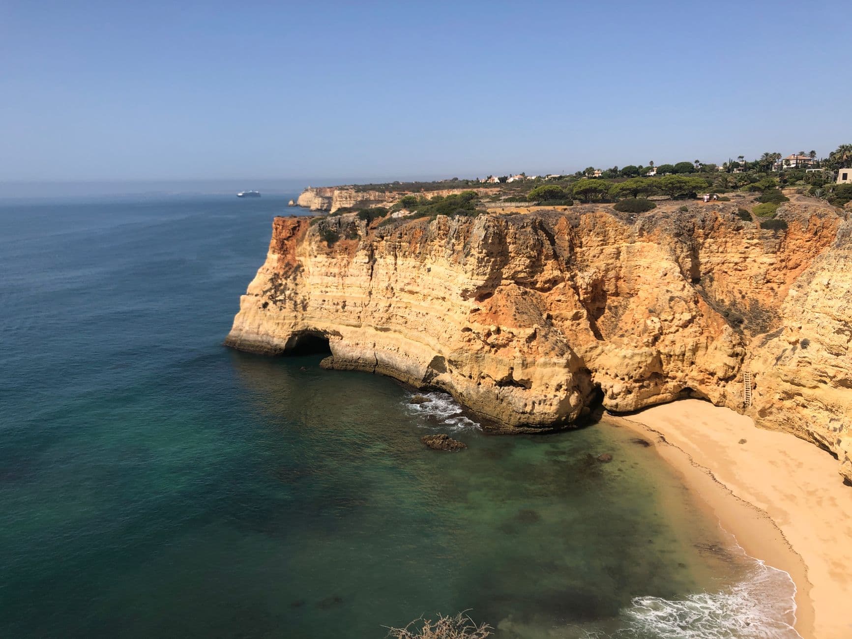 Okerkleurige kliffen en een strand aan de kust van de Algarve