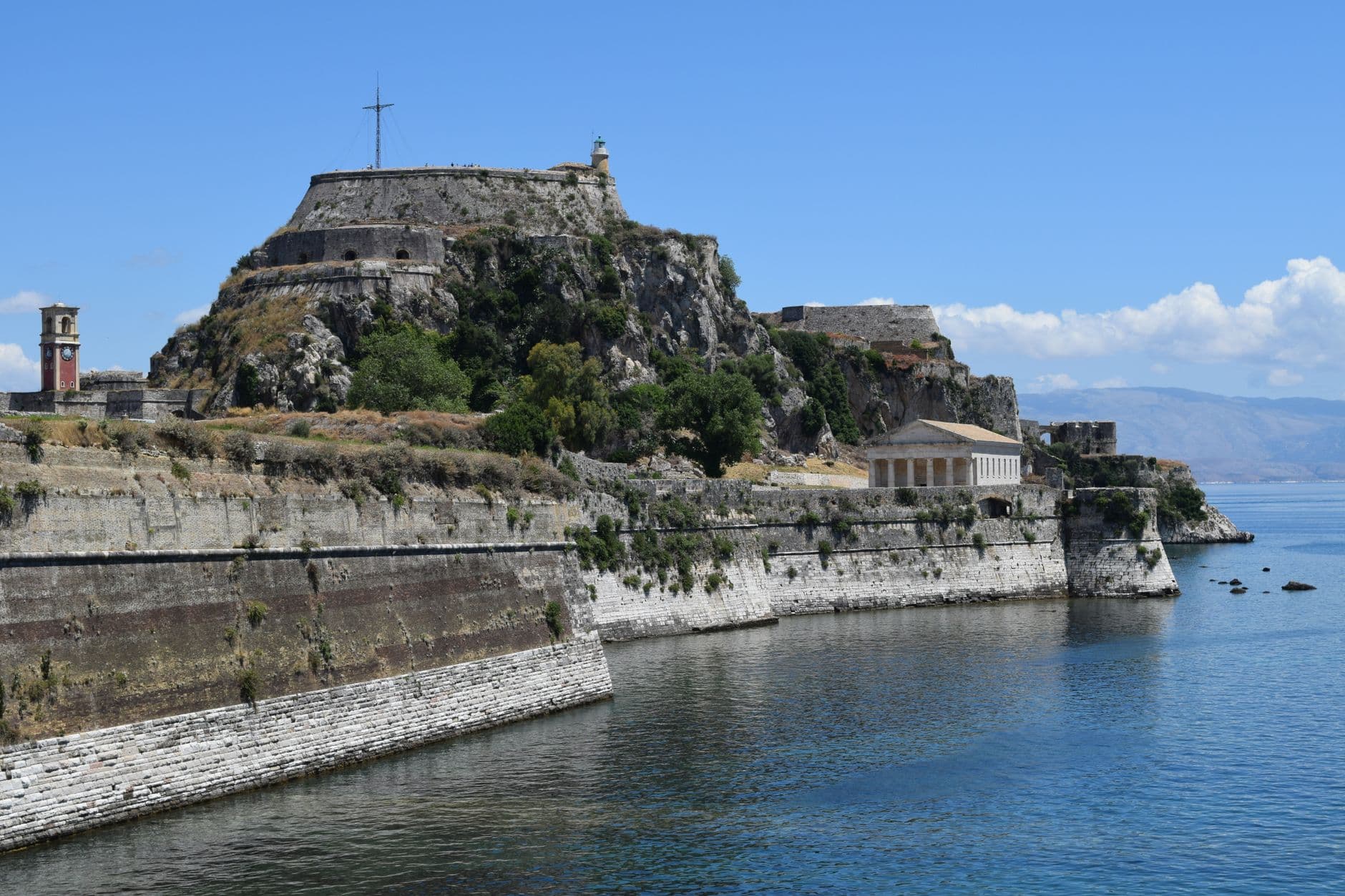 Het oude fort van Corfu aan zee, onder een blauwe lucht