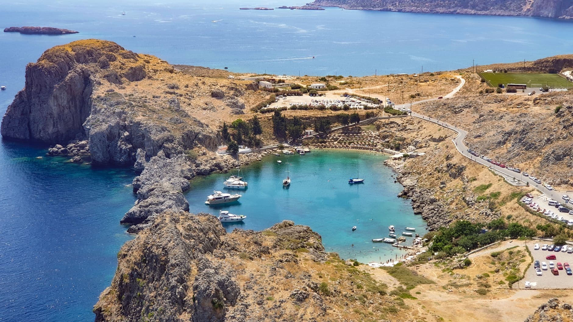 Zicht van bovenaf op de Sint-Paulusbaai op Rhodos, met turquoise water, boten en rotsen