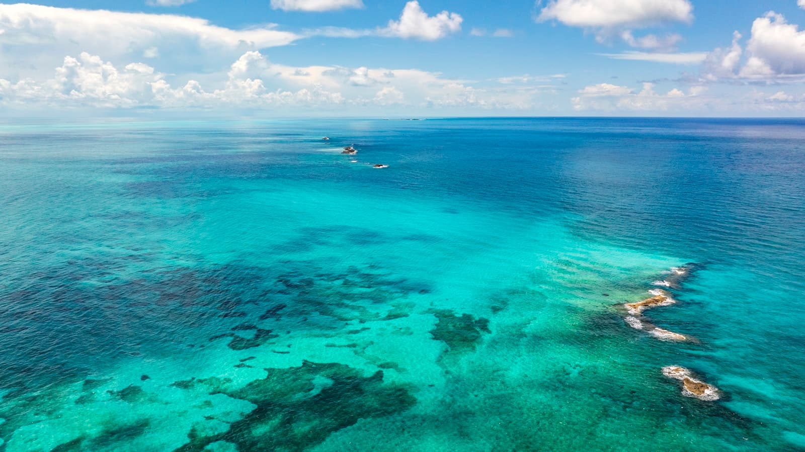 An aerial view of the ocean with boats in the water