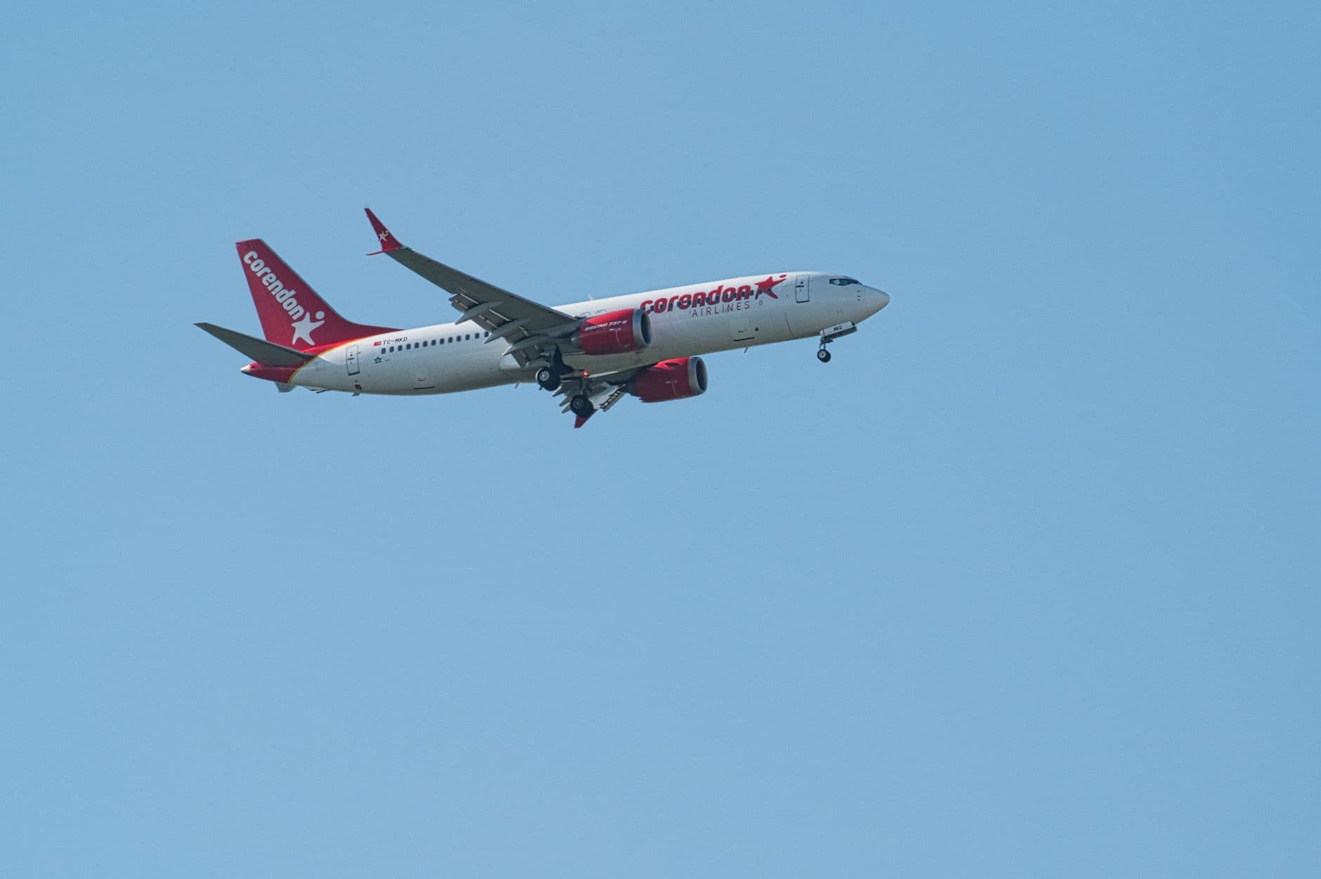 Corendon Airlines passenger jet captured mid-flight against a clear blue sky.