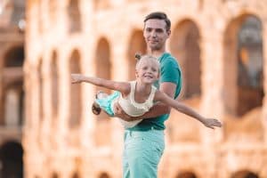 Jonge vader en klein meisje nemen selfie in het Colosseum. Familieportret op beroemde plekken in Europa