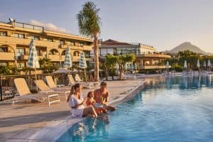 Gezin geniet van ijsjes bij het zwembad van het Grand Palladium Sicilia Resort & Spa in Campofelice di Roccella, Sicilië, Italië