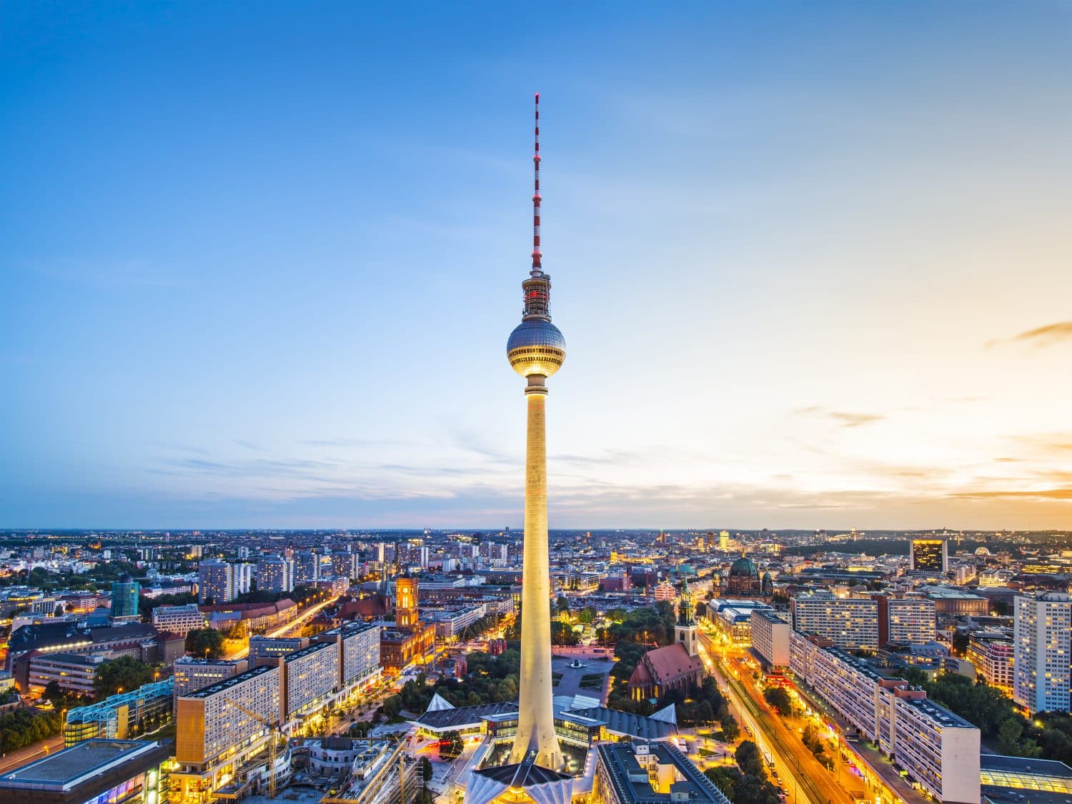 De Fernsehturm boven de daken van Berlijn bij zonsondergang