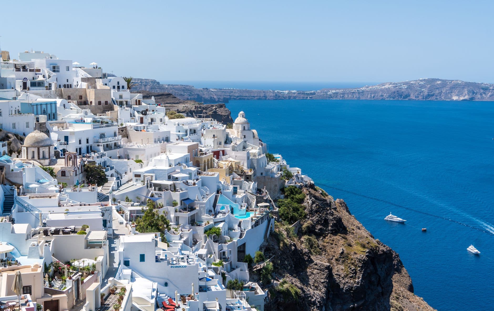Witte huisjes boven de blauwe zee op Santorini, Griekenland