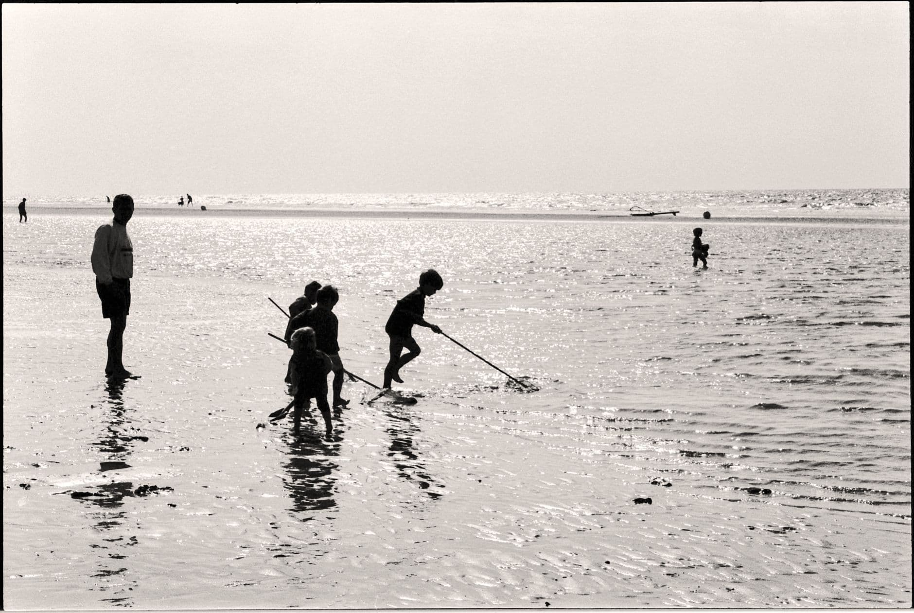 Gezin met spelende kinderen op het strand